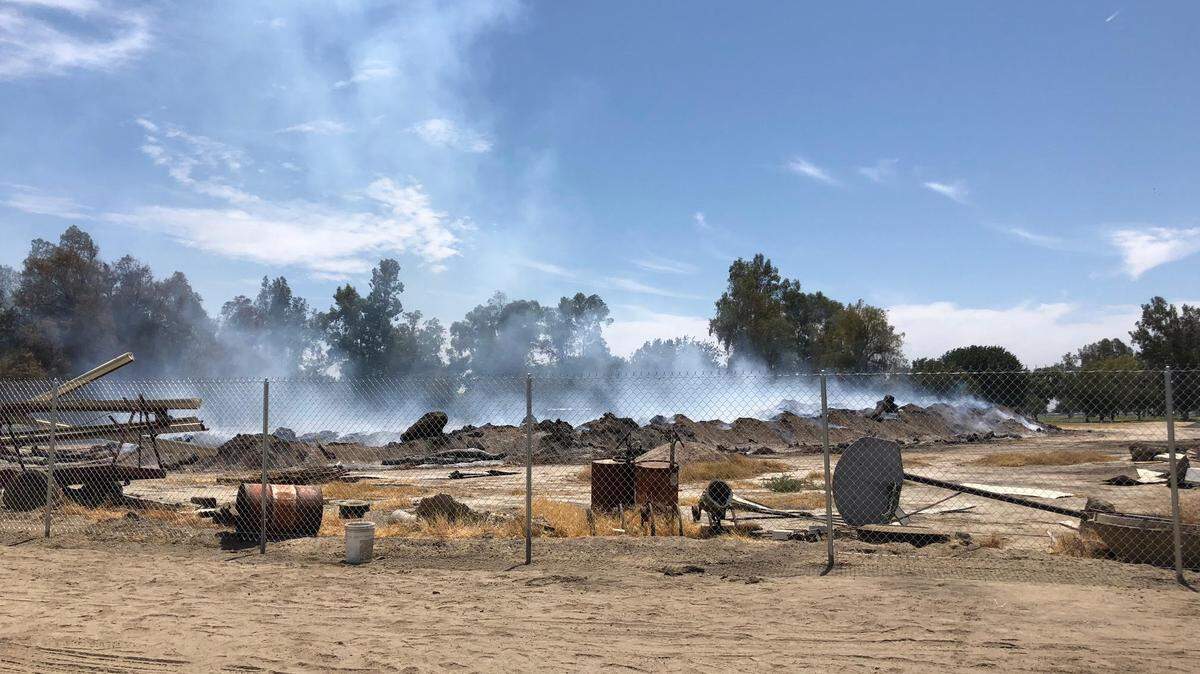 A large debris fire at Tulare Golf Course continued to smolder July 5, 2018.