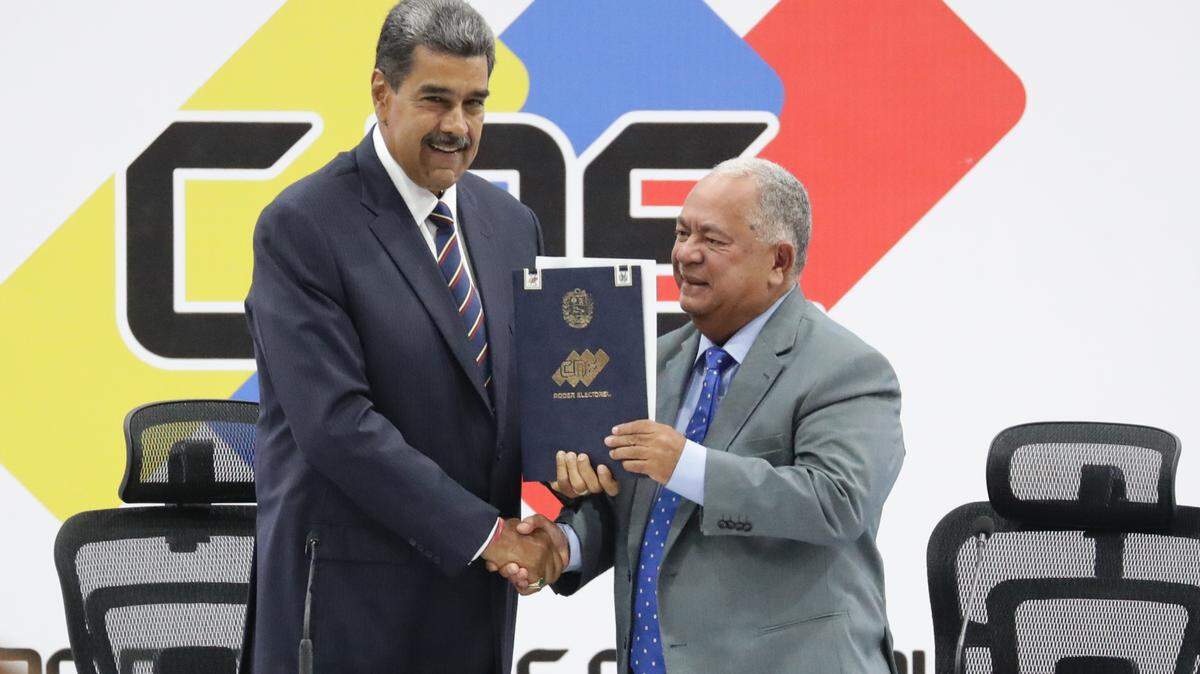 El gobernante de Venezuela, Nicolás Maduro, y el presidente de Consejo Nacional Electoral (CNE), Elvis Amoroso, sostienen el acta de juramentación del presidente electo el lunes 29 de julio de 2024, en Caracas.