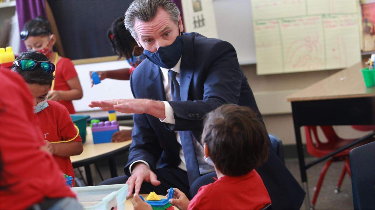 California Governor Gavin Newsom talks with a student in the transitional kindergarten class at Sunset Elementary School in Fresno during a visit to sign a package of early childhood education legislation on Tuesday, Oct. 5, 2021.