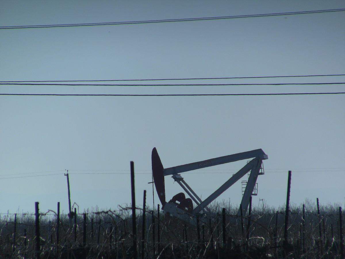 An oil pump station towers over vineyards outside Shafter, CA. 