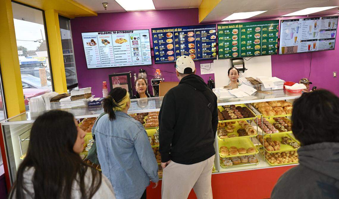 Cusomers gather to order at City Donuts, opened by Tathy Ky and her sister Thida Ky in the former Supreme Donuts location at the corner of Palm and McKinley avenues. Photographed Wednesday, Oct. 22, 2025 in Fresno.