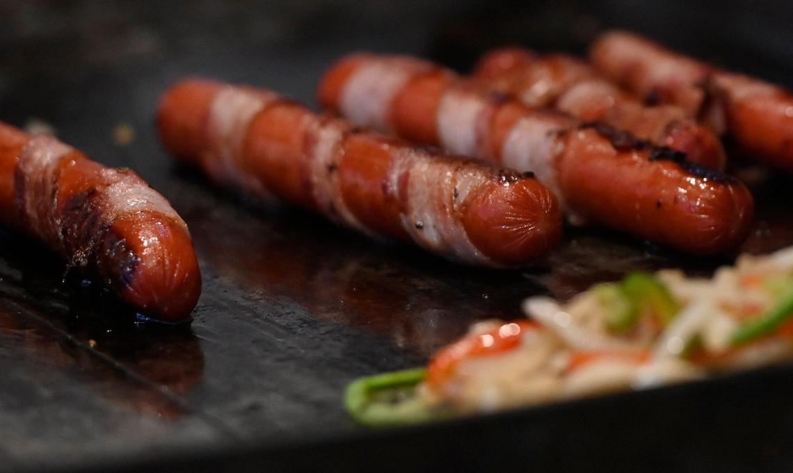 A food vendor sets up shop selling hot dogs on the sidewalk along Olive Avenue in Fresno’s Tower District Wednesday evening, July 19, 2023.