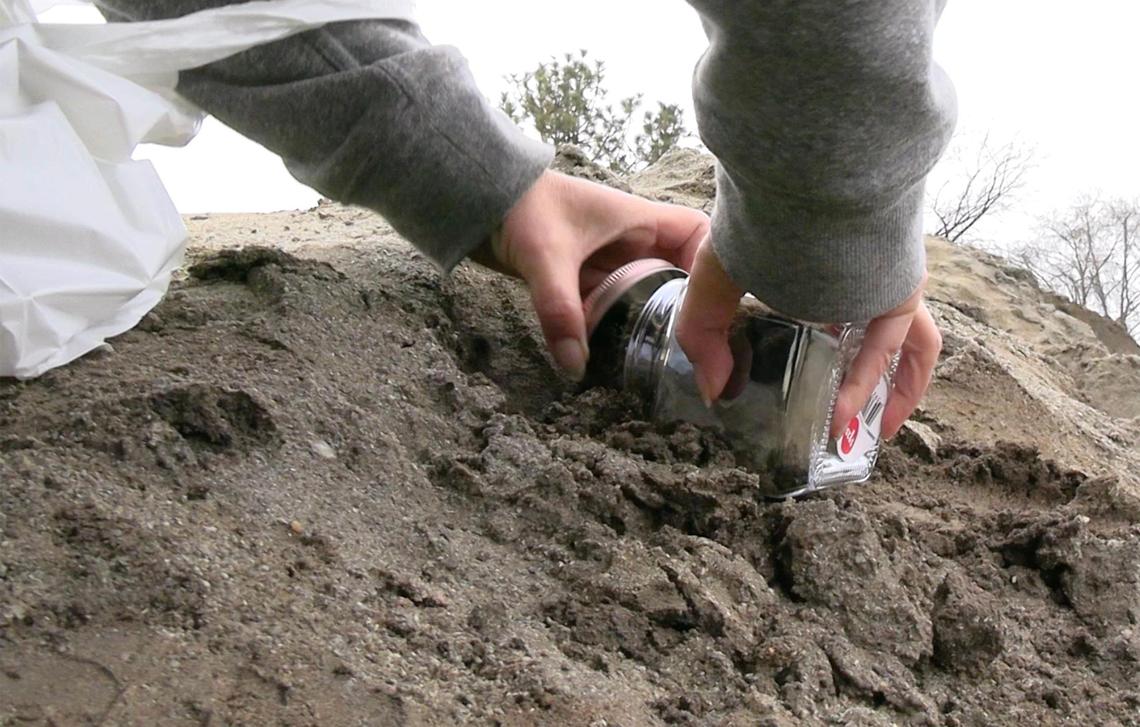 Christine Wengenroth collects jars of dirt as mementos of Mt. Chipotle Friday, Jan. 3, 2025 in Oakhurst. The mound located next to a new Chipotle Mexican Grill may be permanently removed in a few days but until then the community of Oakhurst and others from around the Valley are enjoying the dirt made famous in social media posts.