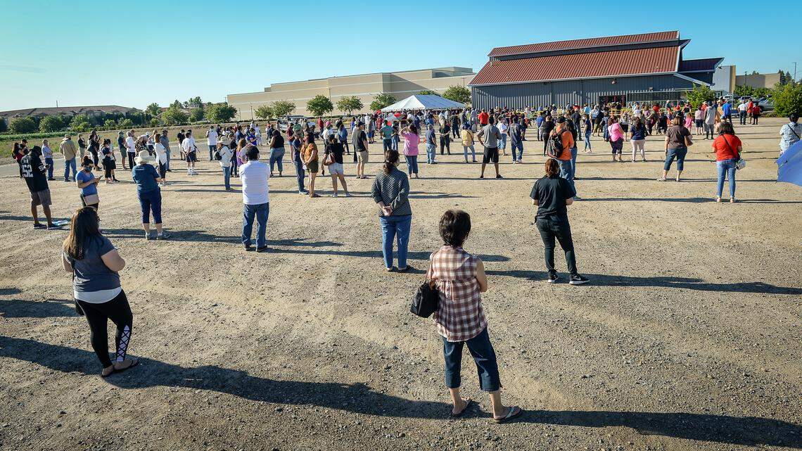 Shoppers wait in line socially distant-style to purchase Fresno State-grown corn on the first day of corn sales at the Gibson Farm Market on Monday, May 25, 2020. This year the market had two lines for people who wanted to just buy pre-bagged corn and for those wanting to purchase other items.