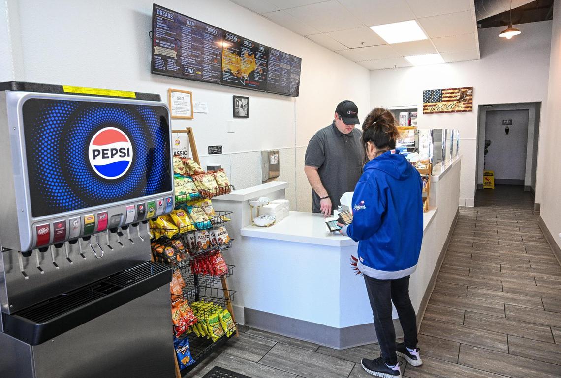 Arnold Karaoglan, owner of the Eagle Sandwich Co. in north Fresno, takes a customer’s order at his shop which opened last June in honor of his father, Eser Karaoglan, who helped him finance the business.