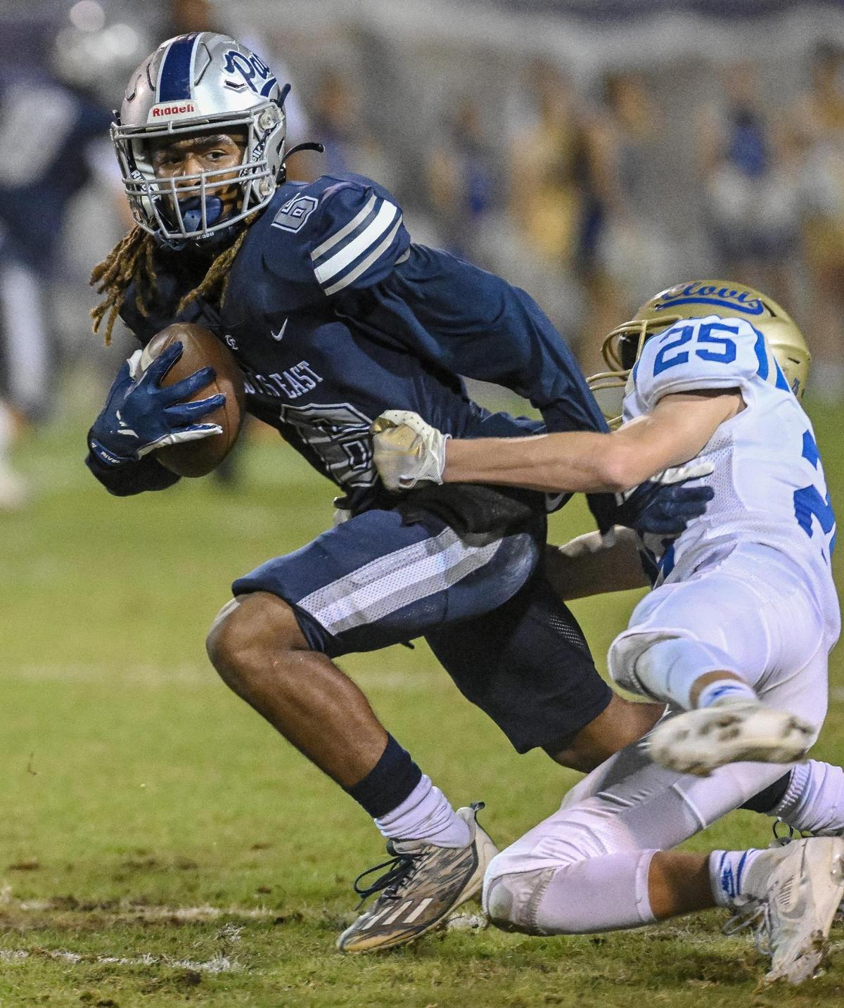 Clovis East’s Donyell Booker, left, tries to pull out of the grasp of Clovis’ Dalton Byrd before gaining extra yardage during their game at Lamonica Stadium on Friday, Oct. 20, 2023.