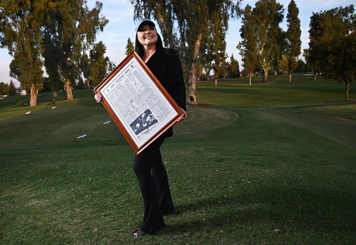 Stephanie Bakula-Ribeiro, seen at Fort Washington Country Club, holds a framed copy of the 1974 front page of The Fresno Bee containing the article about her father Mike Bakula’s infamous golf shot. The 50th anniversary is Friday, October 11.