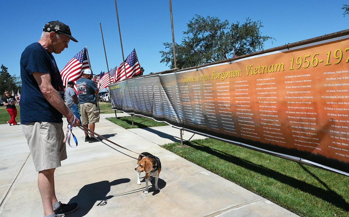 Gary Wright, an Air Force veteran who serve din Vietnam, reads the name son a banner at the 59th Annual VFW Memorial Day Service at Fresno Memorial Gardens Monday, May 30, 2022 in Fresno.