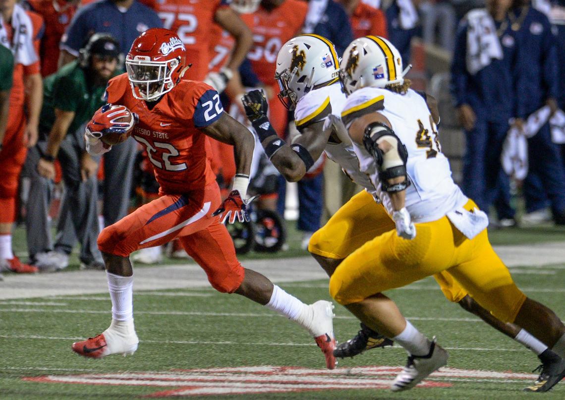 Fresno State running back Jordan Mims, left, races down the sideline for a first down in the Bulldogs’ 27-3 victory over the Wyoming Cowboys at Bulldog Stadium in Fresno on Saturday, Oct. 13, 2018.