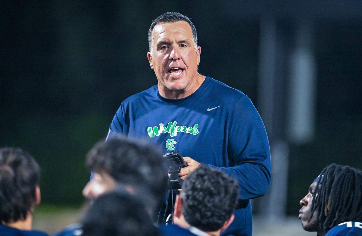 Clovis East head coach George Petrissans talks to his players following their win against Bullard at Lamonica Stadium on Friday, Aug. 22, 2025.