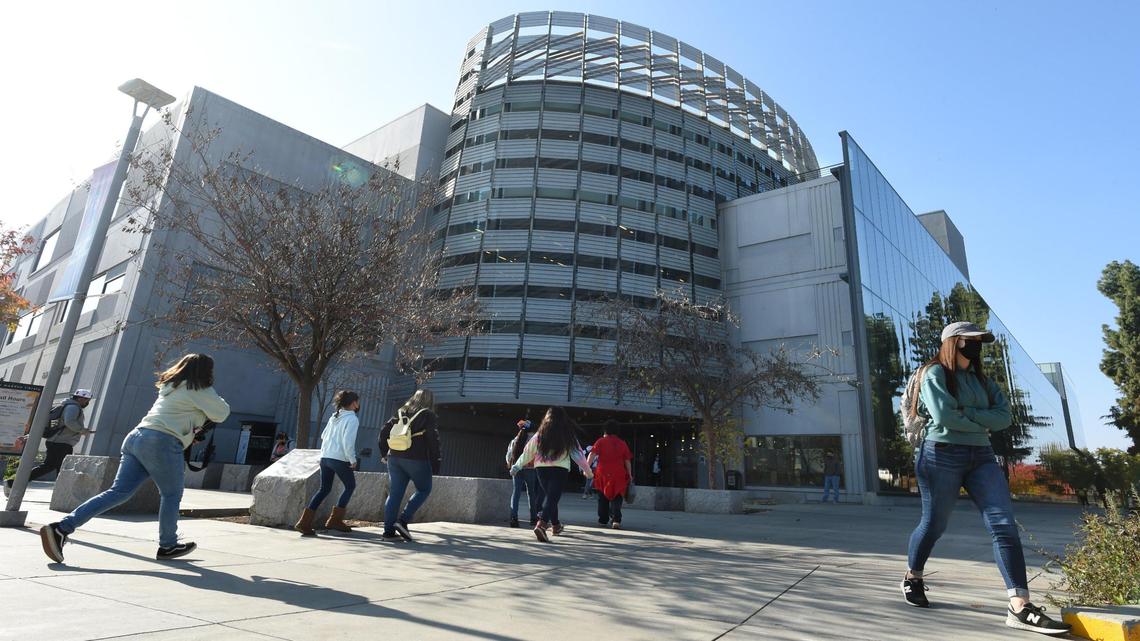 Students and visitors come and go at the Henry Madden Library at Fresno State, Nov. 30, 2021.