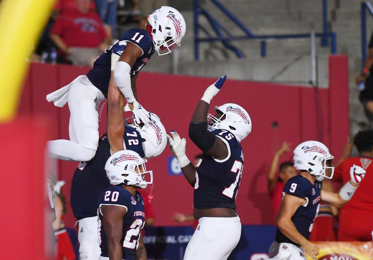 Fresno State wide receiver Josh Kelly, top left, gets a lift from tackle Dontae Bull in celebration for his touchdown reception against Cal Poly Saturday, Sept. 11, 2021 in Fresno.