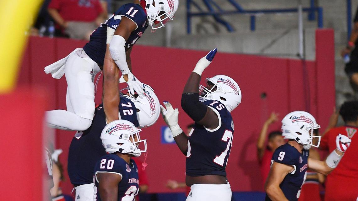 Fresno State wide receiver Josh Kelly, top left, is lifted in celebration for his touchdown reception against Cal Poly Saturday, Sept. 11, 2021 in Fresno.