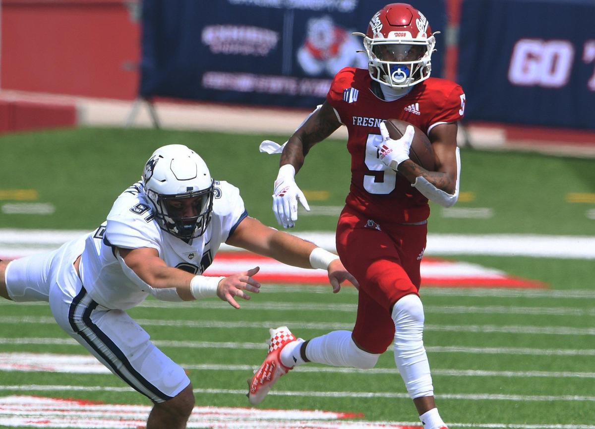 Fresno State’s Jalen Cropper, center, eludes UConn’s defense Saturday, Aug. 28, 2021 in Fresno. The Bulldogs led 31-0 at halftime.