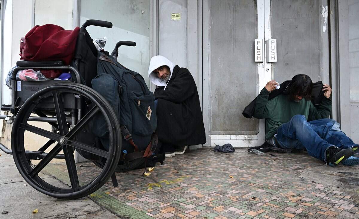Two homeless men take shelter from the rain in a doorway in Fresno's Chinatown Wednesday morning, Dec 24, 2025 in Fresno.