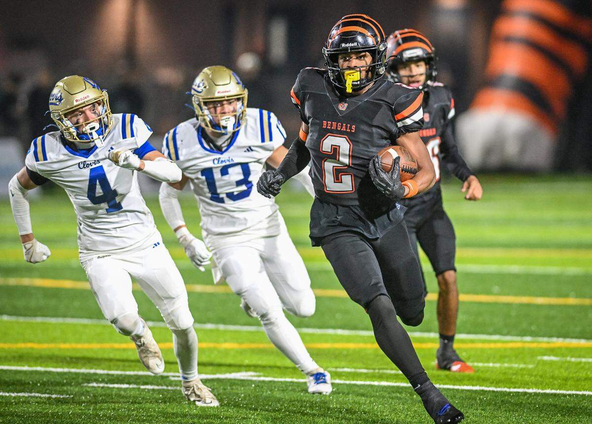 Central East's Brandon Smith turns the corner on Clovis defenders Dalton Byrd, left, and Brenden Kuraspediani during their Central Section Division I-AA championship game at Deran Koligian Stadium on Friday, Nov. 21, 2025.