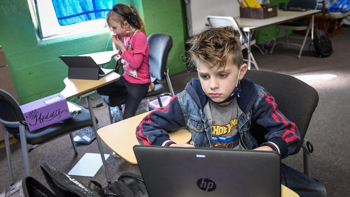 Maddux Delahay, 8, and his sister Hadessa, 7, work on laptops while attending online education classes in a room with other Fresno Unified students at On Ramps Covenant Church in the Lowell neighborhood of Fresno on Friday, Dec. 4, 2020.