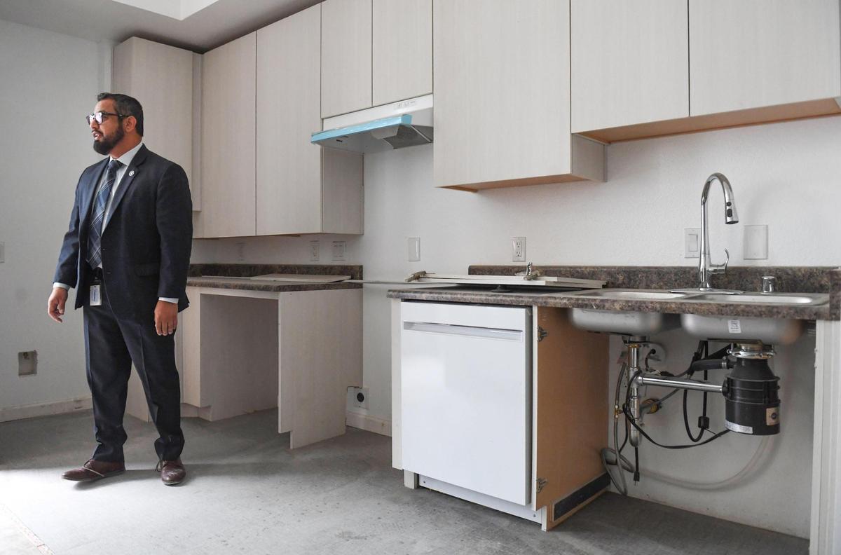 Fresno city councilmember Miguel Arias looks around a kitchen in an apartment unit nearing completion in the historic Hotel Fresno, currently being renovated as an affordable apartment housing project, on Thursday, Oct. 7, 2021.