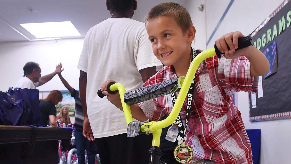 Arsen Petersen, 7, smiles as he straddles the new bike hea earned for reading over 40 books in the Books For Bikes summer reading program at the Zimmerman Boys & Girls Club Thursday, Aug. 15, 2019 in Fresno. Boys And Girls Clubs of Fresno County, partnering with Granville Homes, donated 125 bikes, helmets and locks for the top performing readers, with local bike shop Rubber Soul assembling the bikes and Derrel’s Mini Storage offering storage of the bikes during the summer.