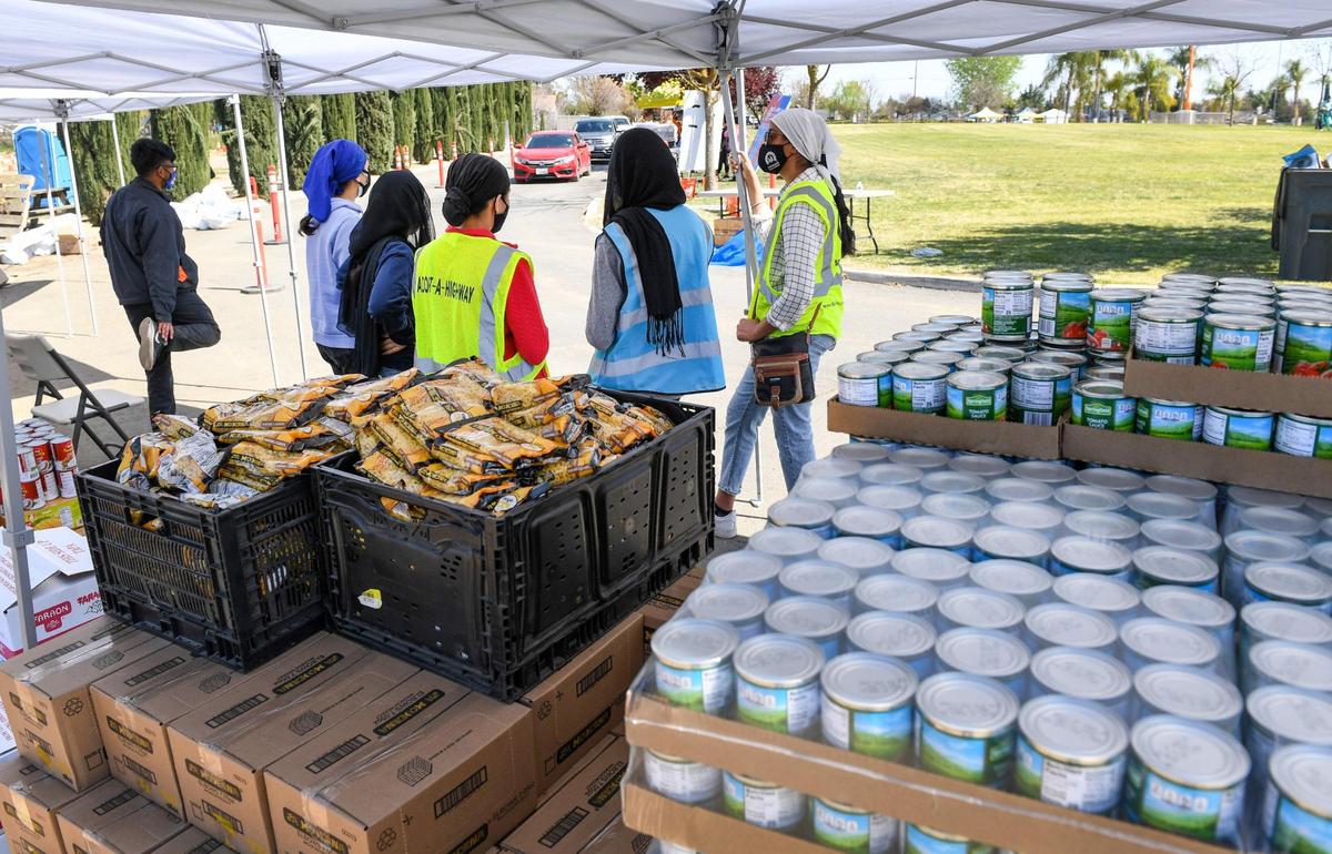 Members of the Jakara Movement help hand out food for those in need during a COVID-19 vaccination and resource fair for over 1000 Punjabi food and agriculture workers at the Sikh Center of the Pacific Coast Gurdwara in Selma, on Saturday, March 27, 2021.