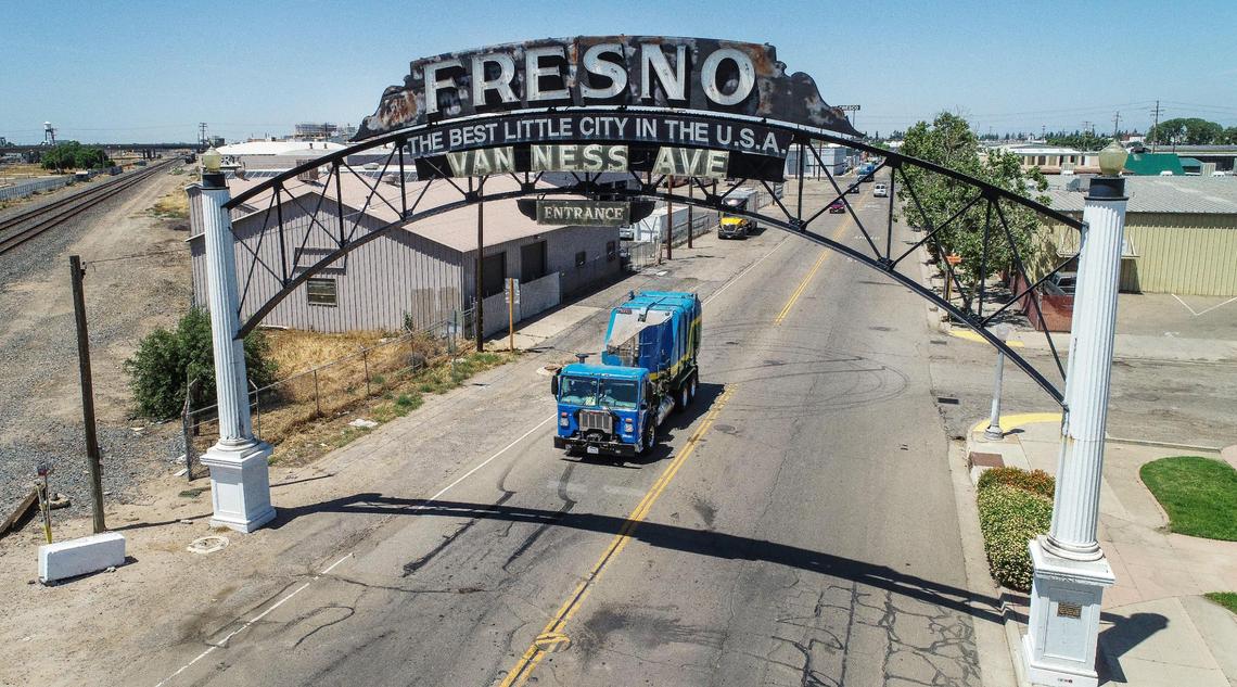 A Fresno garbage truck passes beneath the Van Ness Avenue arch south of downtown Fresno on Thursday, May 17, 2023. Mayor Jerry Dyer presented his fiscal year 2024 mayor’s budget which includes a rate increase for the city Department of Public Utilities residential trash collection services.