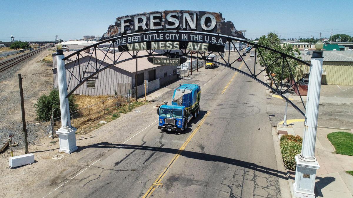A Fresno garbage truck passes beneath the Van Ness Avenue arch south of downtown Fresno on Thursday, May 18, 2023. Mayor Jerry Dyer presented his fiscal year 2024 mayor’s budget which includes a rate increase for the city Department of Public Utilities residential trash collection services.