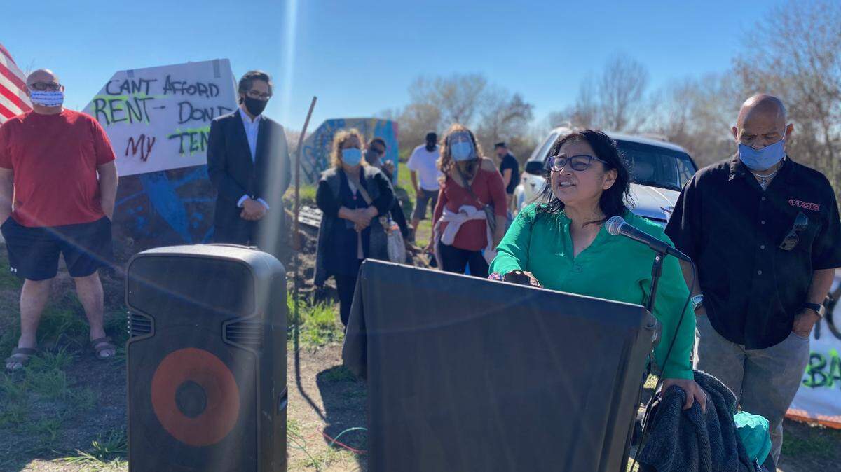 Mari Perez-Ruiz, executive director for the Central Valley Empowerment Alliance, kicks off a news conference along the Tule River in Tulare County. Unsheltered people living along the river have filed a lawsuit against the Tulare County Sheriff’s Office for attempting to clear their encampment when shelter space is unavailable.