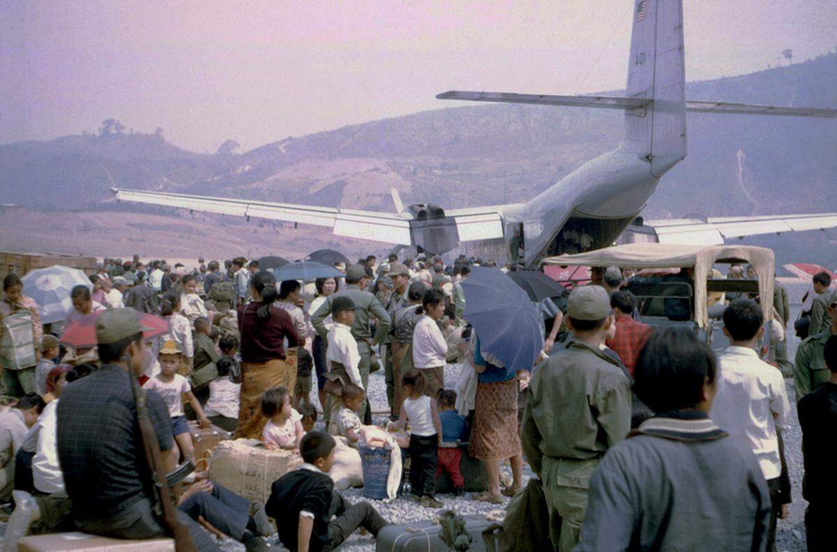 Galen Beery photographed displaced people, including Hmong and Laotian individuals, waiting to board evacuating flights leaving Laos at the Sam Thong airstrip in 1970.