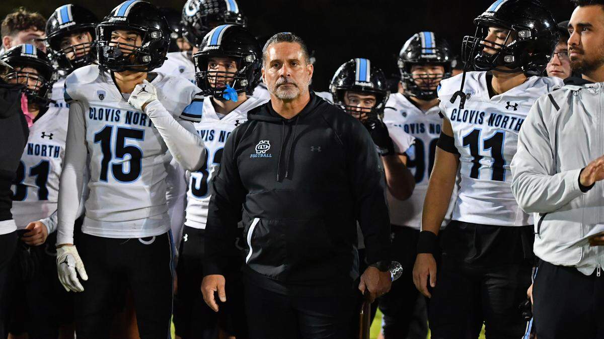 Clovis North head coach Mike Jacot holds the second place plaque while watching as the De La Salle Spartans celebrate after winning their NorCal Division I-AA regional championship game at De La Salle High School in Concord, Calif., on Friday, Dec. 1, 2023. De La Salle defeated Clovis North 41-0.