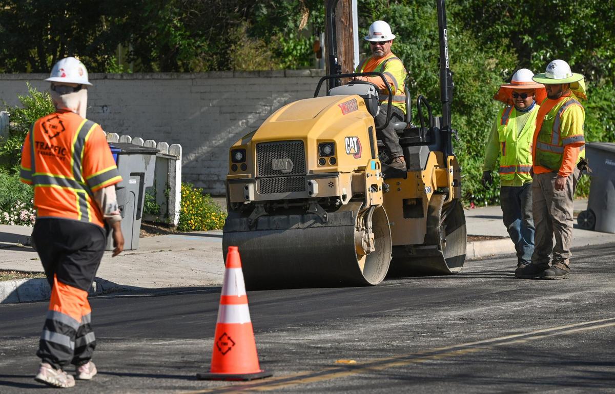 Workers work on Palm Avenue south of Shields on Friday, May 19, 2023, as the prep the road for the installation of new bike lanes.