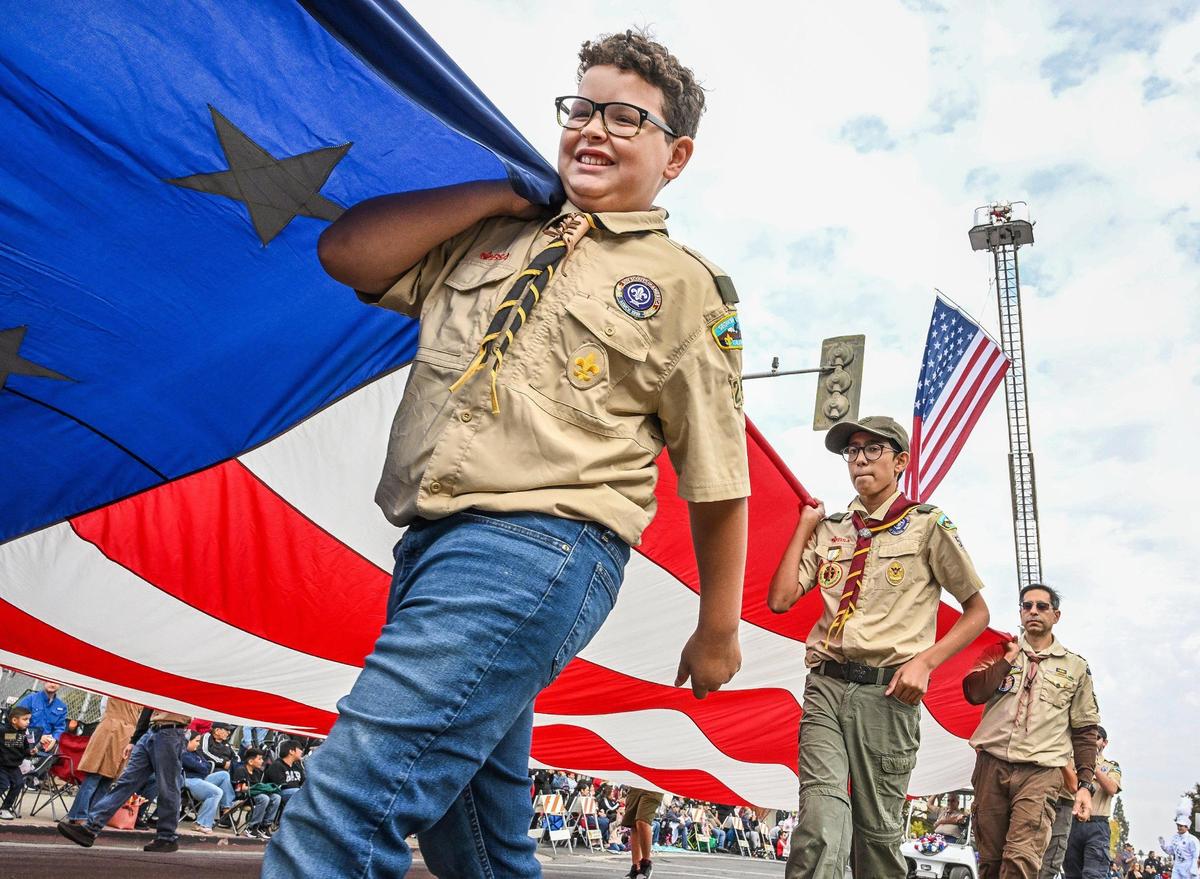 Boy Scouts from Clovis’ Troop 257 carry a giant American flag to start the 105th annual Central Valley Veterans Day Parade in downtown Fresno on Monday, Nov. 11, 2024.
