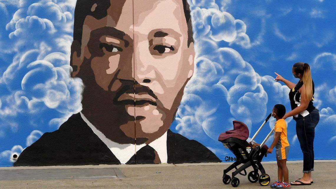 Keshia Thomas, of the Fresno Unified School Board, shows her 3-year-old grandson, Robert Thomas, the Martin Luther King Jr. mural which was unveiled at King Elementary on Monday Sept. 14, 2020.
