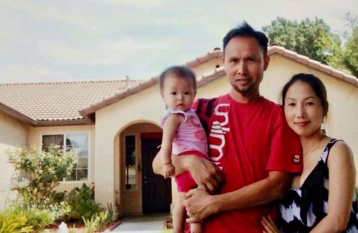 Kalaxang Thao with his wife Maikha Vang and one of their daughters in front of a family member’s home.