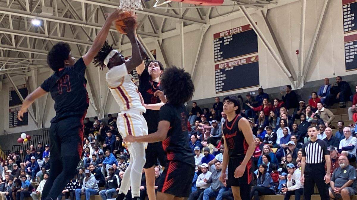 DJ Stickman, de Clovis West, es rodeado por varios jugadores de San Joaquin Memorial durante su partido de cuartos de final de la División I de la Sección Central, el jueves 15 de febrero de 2024.