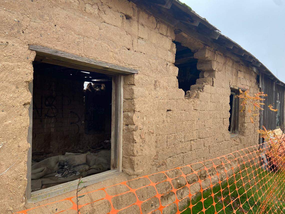 The Jose Garcia (Brewer) Adobe sits behind a plastic fence near Shaw Avenue west of Highway 99 in Fresno, California, on December 5, 2021. The adobe brick and hardpan structure, placed on the Local Register of Historic Resources in 1997, is under threat by a developer who originally requested its demolition.