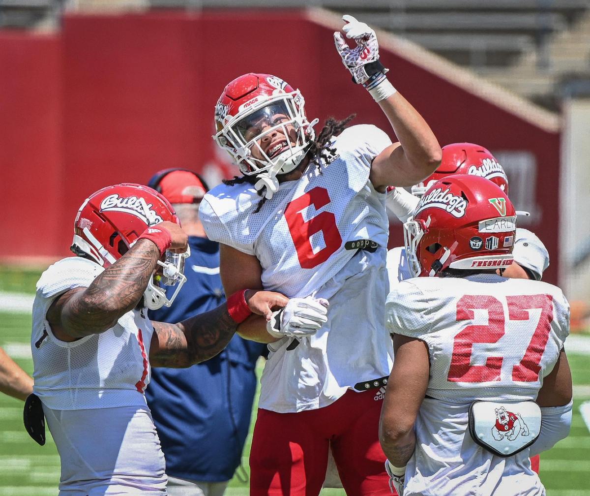 Fresno State linebacker Levelle Bailey celebrates with teammates after stopping the offense on a 4th down play near the goal line during the Bulldog football team’s spring preview at Bulldog Stadium on Saturday, April 30, 2022.