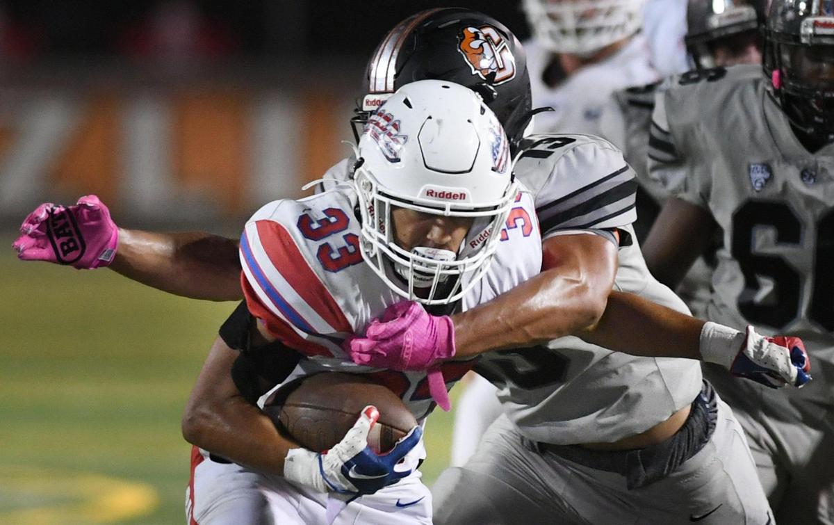 Buchanan’s Michael Runnels, foreground, is tackled by Central’s Caleb Shelton, background, Friday, Oct. 7, 2022 in Fresno. Buchanan won 49-41.