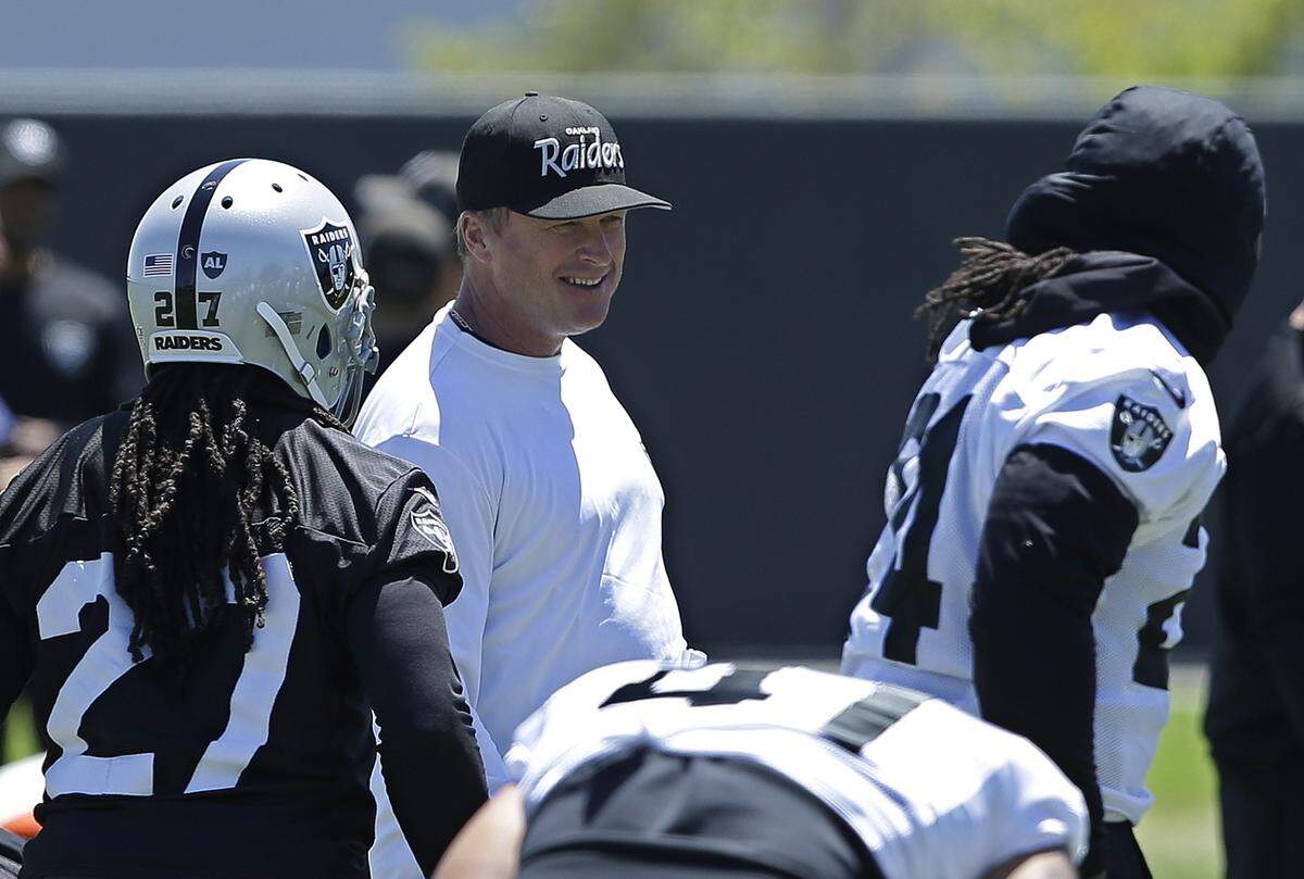Oakland Raiders coach Jon Gruden talks with running back Marshawn Lynch, right, at the team's mandatory minicamp Wednesday, June 13, 2018, in Alameda.