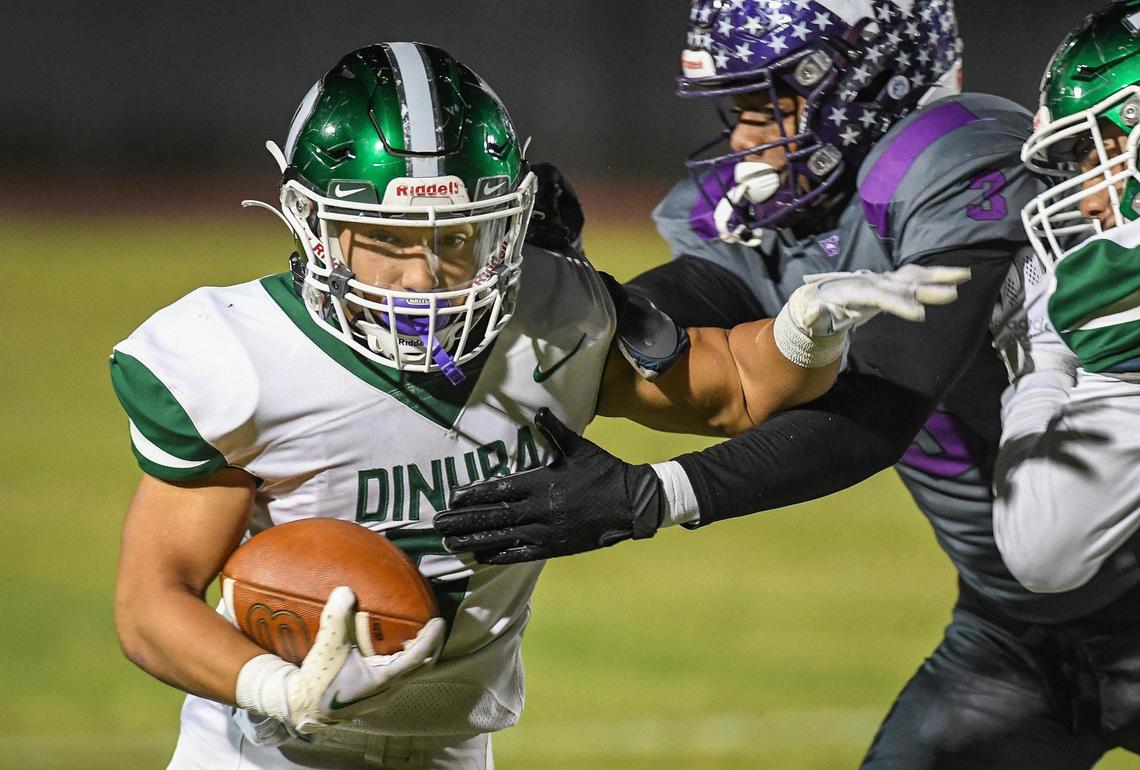 Dinuba’s Marcos Nunez tries to get by Washington Union’s Ryan Brown Jr on a run in their Central Section Division II playoff game at Jesse Ventura Stadium in Easton on Friday, Nov. 4, 2022.