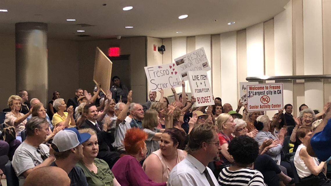 Residents at a June 2018 Fresno City Council meeting wave signs to encourage the council to find funds to establish a senior citizens activity center in Fresno. Fresno is the fifth largest city in the state, yet unlike many smaller communities in the county has no dedicated senior citizens center.