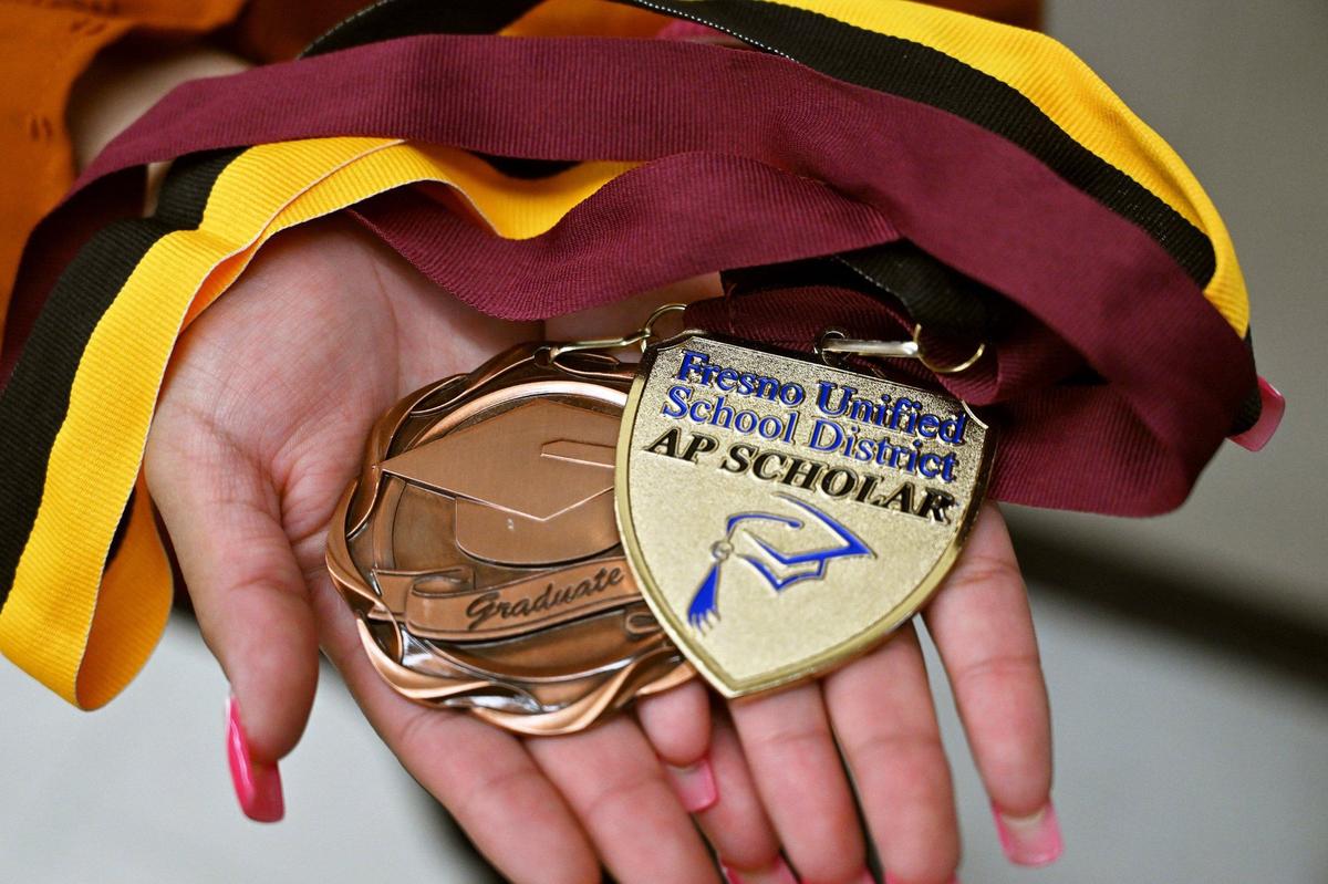 Mayra Hernández García, de 18 años, originaria de Fresno y estudiante de último año en Edison High School, sostiene las medallas que le fueron otorgadas. Ella tendrá beca completa a partir de este agosto en la Johns Hopkins University. Fotografía del martes 14 de mayo de 2024, en Fresno.