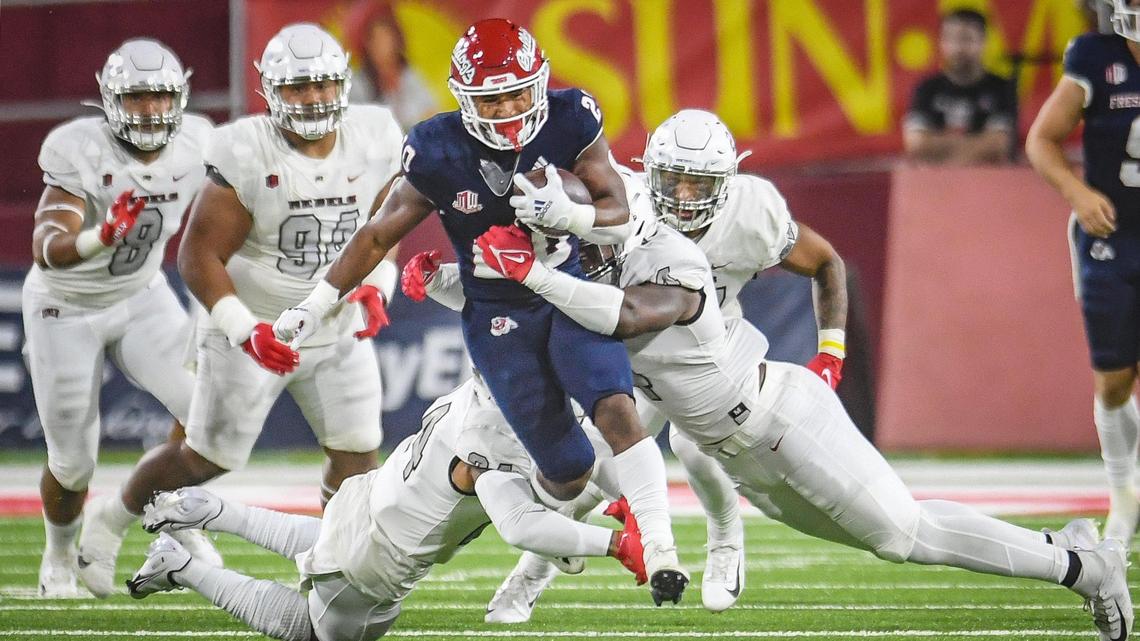 Fresno State’s Ronnie Rivers, center, drives for a few yards up the middle during their game against UNLV at Bulldog Stadium on Friday, Sept. 24, 2021.