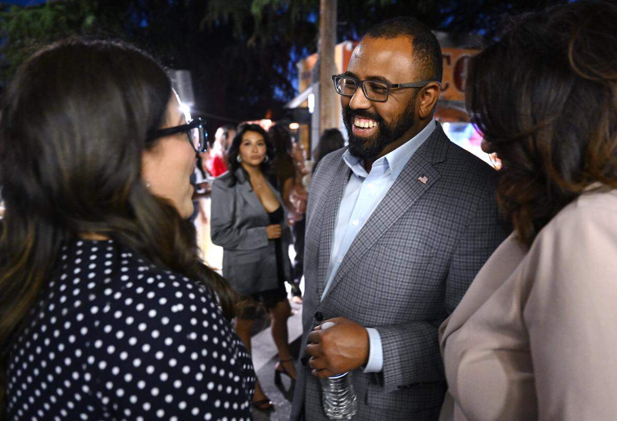 Nelson Esparza, center, laughs with Esmeralda Soria, left, at a campaign gathering Tuesday night, June 2, 2026 in Fresno.