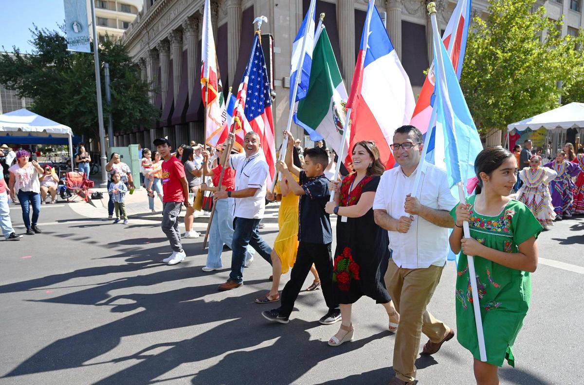 Marchers with the U.S. and California state flags, as well as flags of Mexico and other Latin American countries, lead the Fiestas Patrias parade celebrating Mexican Independence Day and more in its return to downtown Fresno on Saturday, Sept. 17, 2022.