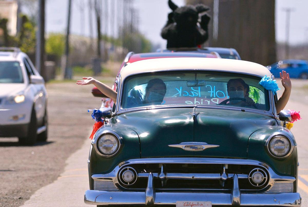 The lead car in a long procession, with the school’s mascot riding a few cars back, makes its way through the community as West Park Elementary staff hold a drive-by parade to wish their home-bound students well Thursday, April 2, 2020 in West Park, southwest of Fresno.