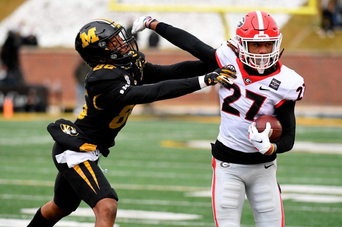 Former Georgia defensive back Eric Stokes (27) runs with the ball after intercepting a pass as Missouri wide receiver Tauskie Dove (86) defends during the first half of an NCAA college football game Saturday, Dec. 12, 2020, in Columbia, Mo.