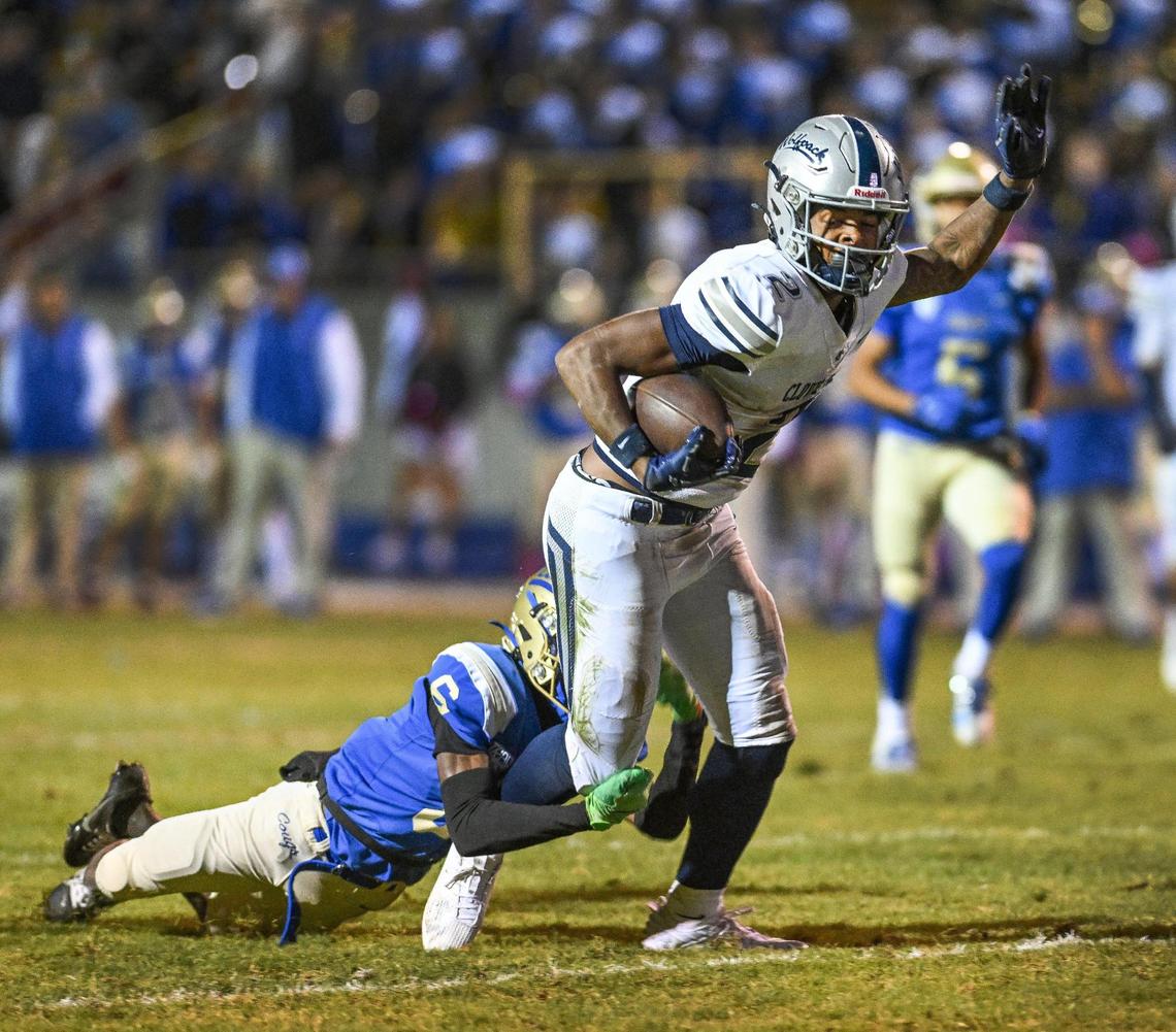 Clovis East’s Lindsey Graves, right, tries to pull away from Clovis’ Carlos Young after a catch during their game at Lamonica Stadium on Friday, Oct. 18, 2024.
