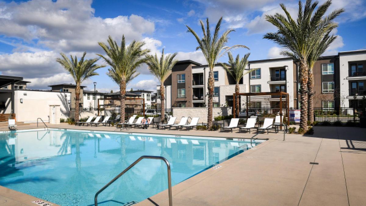 The pool area of The Row at Heritage Grove is surrounded by palm trees and upscale apartment units on a cool day on Wednesday, Feb. 18, 2021. The new community at the northeast Fresno/Clovis border touts numerous amenities, including a fitness center, as well as many nearby biking, walking and jogging paths.