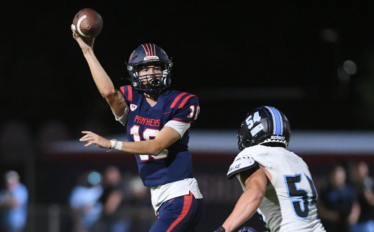 San Joaquin Memorial quarterback Carson Dean passes as Clovis North’s Ross Cinfel, right, applies pressure Friday, Aug. 19, 2022 in Fresno.