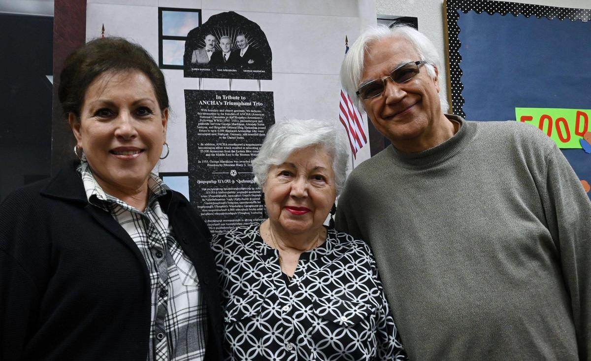 American National Committee to Aid the Homeless Armenians archivist Rosie Megrdichian Bedrosian, left, chair Sophie Mekhitarian, center and co-chair Varoujan Der Simonian, right, pose in front of a model of the 13-foot tall monument at Holy Trinity Armenian Apostolic Church Wednesday, April 12, 2023 in downtown Fresno.